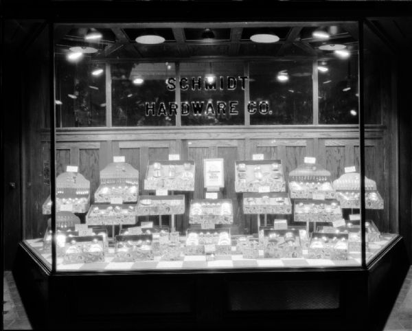 Aluminum Toy Dishes Window Display Window display of the Schmidt Hardware Company showing Mirro Aluminum toy sets: dishes and silverware.