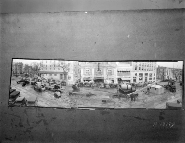 Panoramic elevated view of the east side of Monona Avenue (Martin Luther King Jr. Boulevard,) showing Wisconsin Foundry and Machine Co. road construction equipment on display for the Wisconsin Road Show. With view of the Wisconsin State Capitol, Pioneer Building, Garrick Theatre, Jimmy Dodge's Lunch - Billiards, Beavers Insurance Building and the U.S. Post Office.