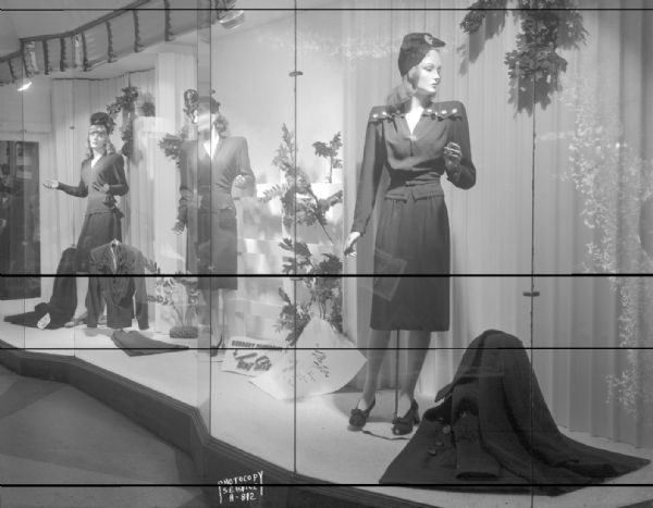 Right side window at Woldenberg's, 26 East Mifflin Street, showing three mannequins wearing dresses and hats. "Herbert Sondheim by Troy Stix."