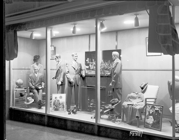 Angle view of four male mannequins in the window of The Hub clothing store, 22 West Mifflin Street.