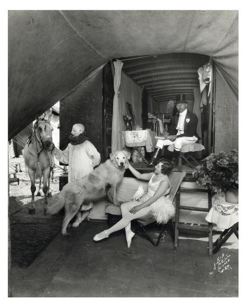 Fred and Ella Bradna, equestrian director and performer for Ringling Brothers, Barnum & Bailey. There are several other performers and a dog, relaxing in their circus wagon.