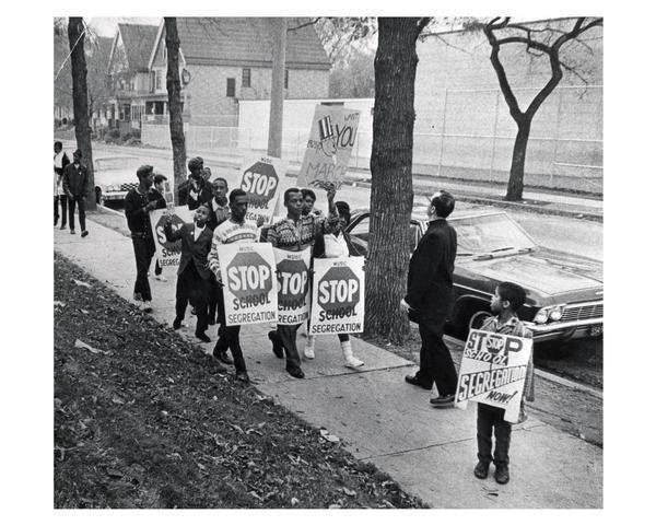 Father James Groppi (1930-) and school desegregation demonstrators marching in. Milwaukee holding signs that read "Stop School  Segregation"