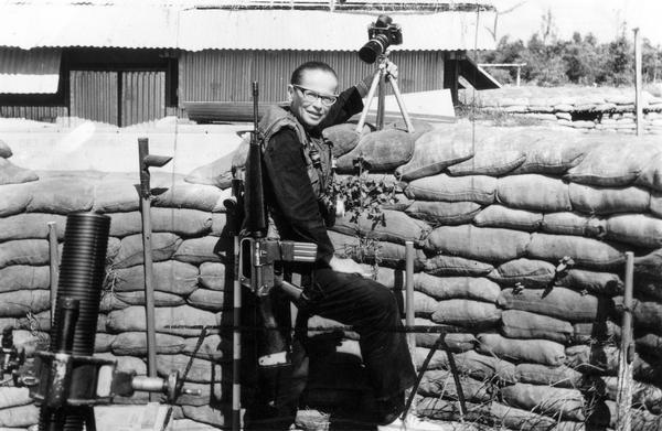 Dickey Chapelle on the Don Phuc command post, in front of a stack of sandbags, on the Vietnam-Cambodia frontier. Chapelle resided at this post for 34 days, photographing combat and participants.