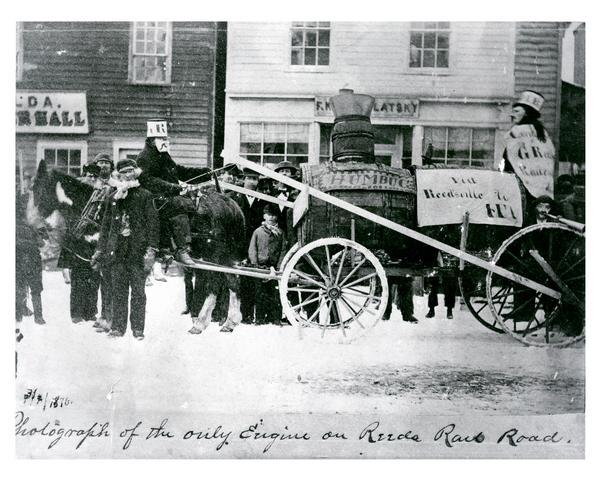 Street parade rig, apparently to agitate against delays in construction of a railroad to connect Manitowoc to the west. In the background is a store owned by F. Kostomlatsky, secretary-treasurer of the Slovanska Lipa (Bohemian Society). Kostomlatsky was a dry-goods and later wholesale liquor dealer. Next to this store is the Turner Hall, with the name Thusnelda Lodge of the Orden der Hermannsoehne, a German organization which used the building as a meeting place.