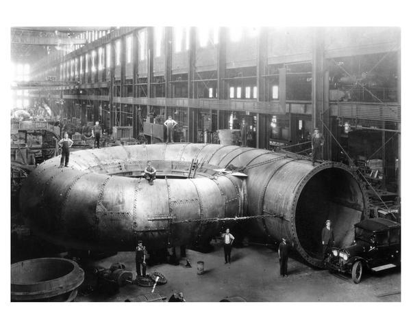 Plate Steel Spiral Casing for 70,000 horse-power Niagara Falls hydraulic turbine unit at the Allis-Chalmers Manufacturing Company erecting shop. The casting inlet diameter is 15 feet while the overall diameter is 50 feet. The plate thickness varies from 7/8 to 1 1/4 inches. Note the automobile in the lower right corner for scale.