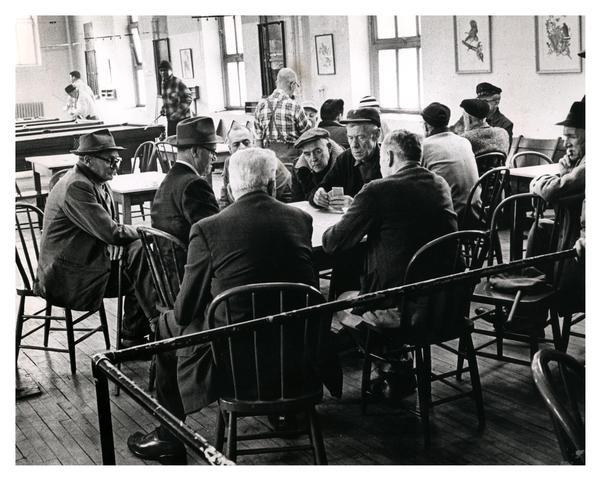 Several men engaged in a serious card game at the Milwaukee Municipal Social Center, one of several centers devoted to social and recreational programs for citizens of all ages.