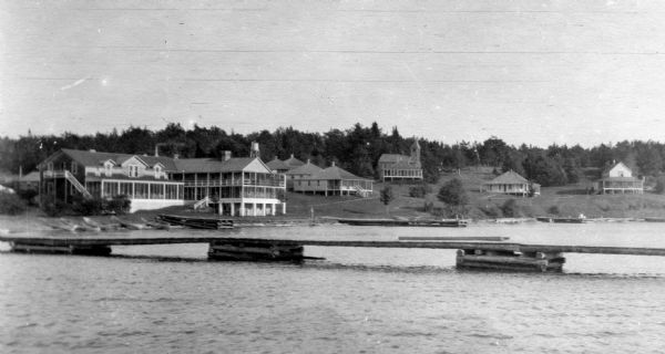 View from the water of the Mission, dock, Mission cottages, and Congregational Church on Madeline Island.
