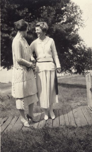 Two young women standing on a boardwalk on Madeline Island.