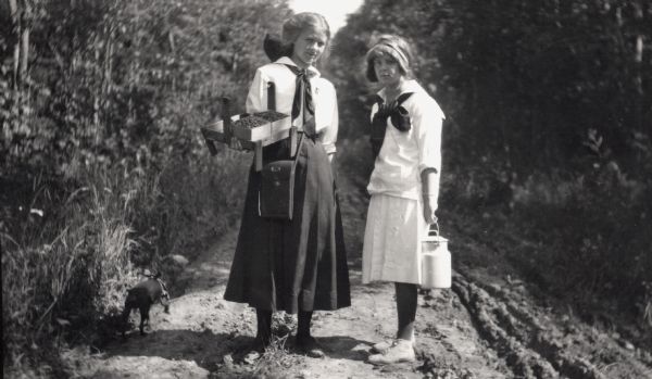 Elizabeth Baker and Anne Ashley gathering raspberries and getting milk on the road to Grant's Point on Madeline Island.