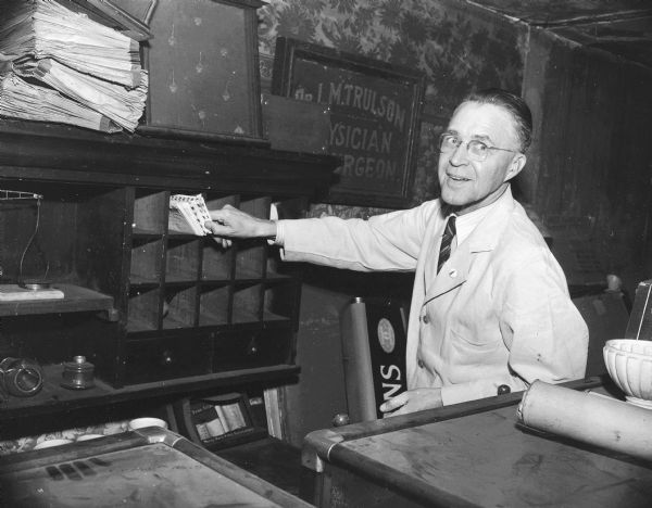 Stoughton druggist, O.N. Falk, sorts the mail with a smile.