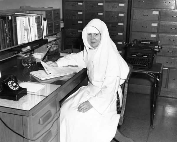 Sister Mary Clara Francis, pharmacist at St. Joseph Hospital, glances up from her paperwork.