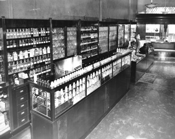 Interior view of one side of Frankfurter Pharmacy, showcasing meticulously arranged pharmaceutical glass bottles in cabinets.