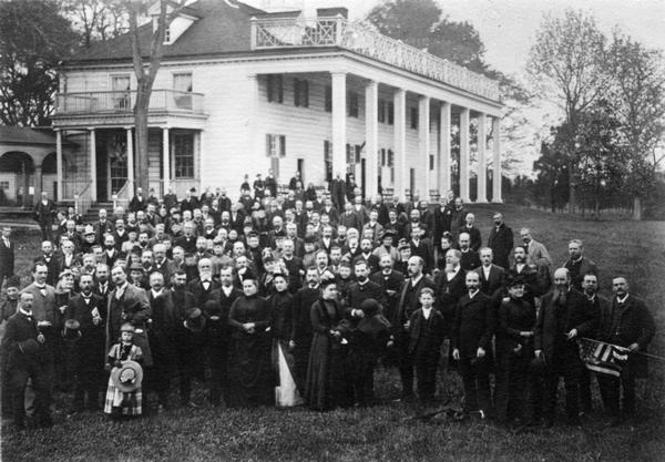Slightly elevated view of the members of the United States Pharmacopeial Convention and their families standing for a portrait at Mount Vernon.