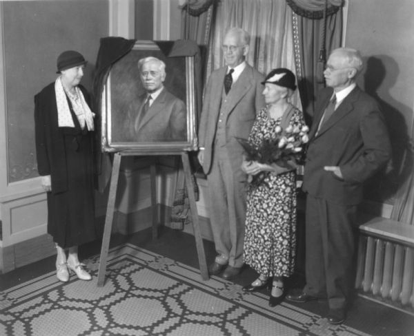 View of a ceremony in which an oil portrait of University of Wisconsin pharmacist Edward Kremers was unveiled. Pictured are (right to left): Nellie Wakeman, Dean George Sellery, and Mrs. and Mr. Kremers.