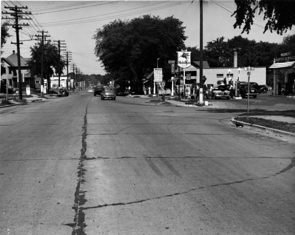 A view down Park Street at Olin Avenue. On the corner of Olin is Moore's Super Service Mobil Station and McCranner Drugs.