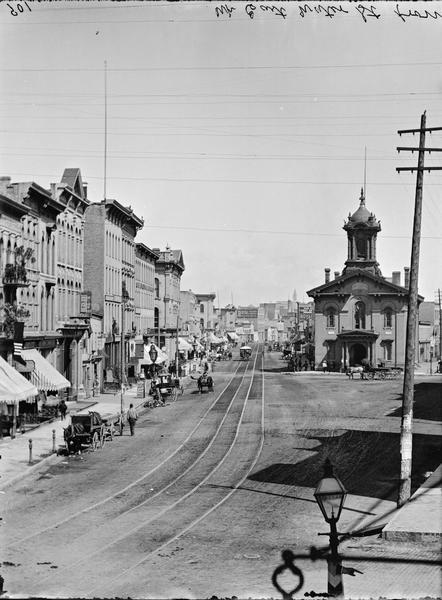 East Water Street from Kirby House. View of buildings and street, with a street car in the distance.