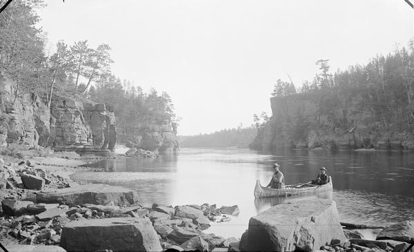 View of Jaws from Stone Pile. Two men are in a canoe.