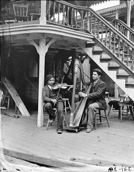Harpist and violinist posed on the steamboat "New Dell Queen."