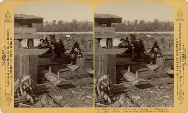 Stereograph of four men sitting by and lying in wooden a-frame shaped "bunks" on the Cook Float. Mike Lane, the Cook, is the nearest man just crawling out of his bunk.