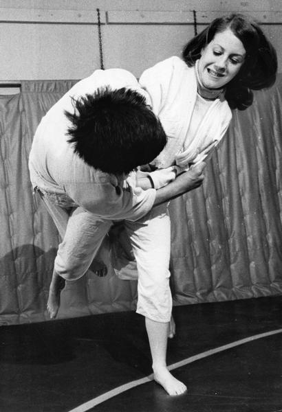 Woman judo student taking down a male opponent in practice for judo tournament.