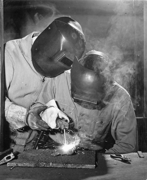 Two students welding at the University of Wisconsin Agricultural Short Course.