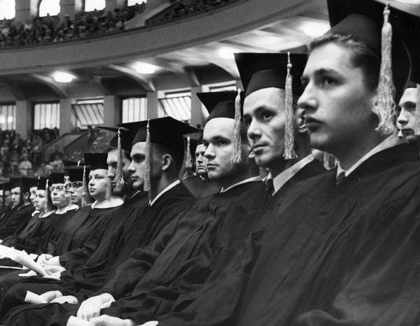 Graduates in caps and gowns attend the graduation ceremony.