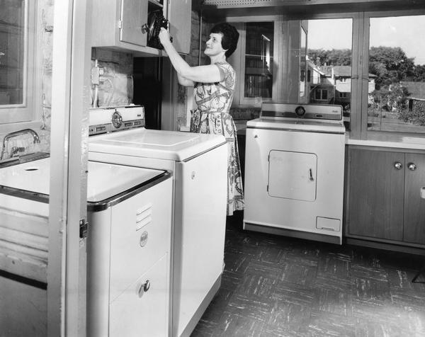 A housewife showing off her newly-installed laundry room.