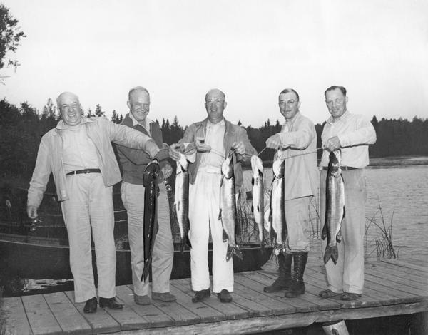 Dwight D. Eisenhower, fishing with his brothers on Wisconsin Lake, proudly exhibit Muskies and one Northern Pike.