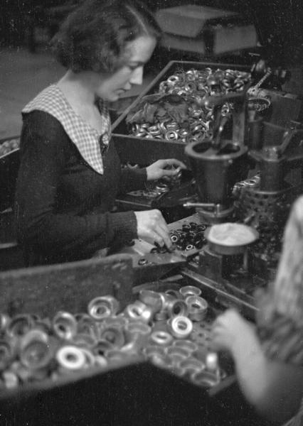 A woman factory worker sorting parts at Globe Union Manufacturing Company, maker of batteries, radio apparatus, and spark plugs.