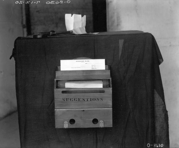 Wooden suggestion box with blank forms at an International Harvester factory (most likely Osborne Works in Auburn, NY).