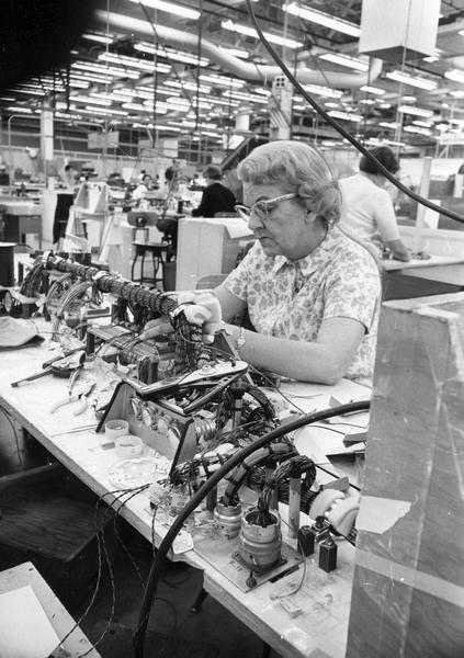 Woman working on a wire harness for the lunar module section of an Apollo spacecraft at the AC Electronics division of General Motors Corp. plant.