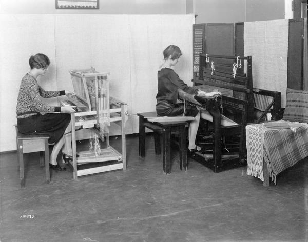 Two women weave at looms in a University of Wisconsin class.