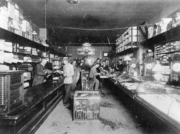 Customers receive assistance from clerks inside a general store.