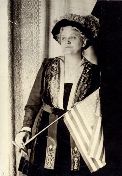 Carrie Chapman Catt, suffragist and peace advocate, holding an American flag.