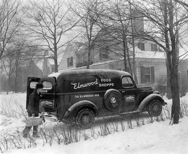 Employee of the Elmwood Food Shoppe making a home delivery with his International D-2 truck.