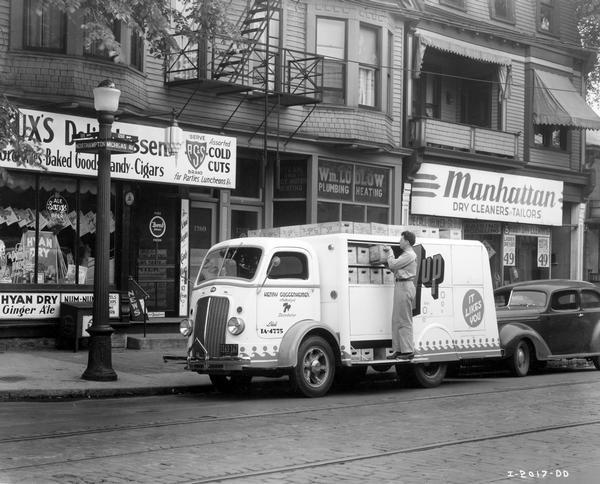 Man unloading cases of 7-Up soda outside a delicatessen at the corner of Michigan and Northampton streets. Truck operated by Henry Guggenheimer.