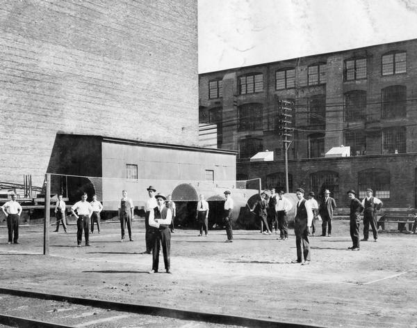 Employees of International Harvester's Deering Works take a break from a volleyball match outside the factory. The match pitted workers from the twine mill against those from the main office. Final score: twine mill 52, main office 27. The Deering Works was originally built by William Deering for the Deering Harvester Company in 1880. In 1902 it became International Harvester's Deering Works. The factory was located at Fullerton and Clybourn Avenues and closed in 1933.