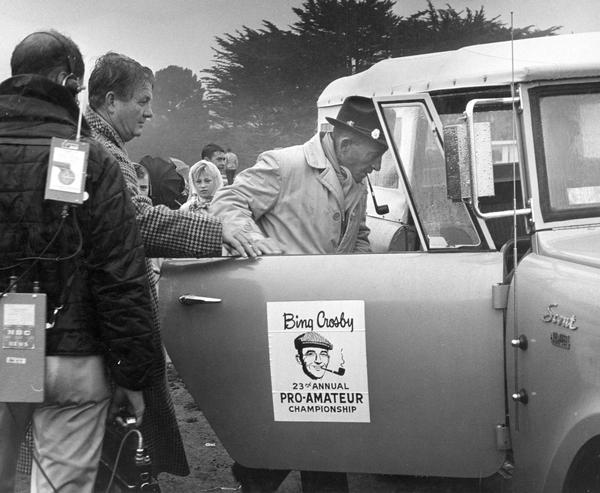 Actor and singer Bing Crosby getting out of a drizzling rain and into an International Scout 4x4 pickup during his 23rd Annual Pro-Amateur Golf Championship, otherwise known as "Crosby's Clambake."