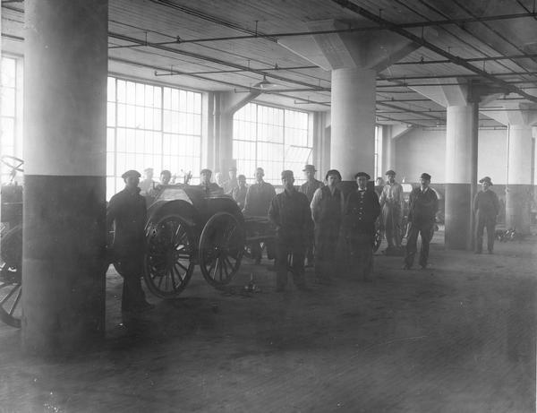 Interior view of truck assembly line workers at IHC's Akron Works factory, Akron, Ohio. The works originally belonged to the Aultman & Miller Buckeye Company until it was bought out by IHC in 1905. Retooled and modernized in 1907, the works unfortunately burned and was rebuilt in 1912. Occupying 11.5 land acres, the works closed in 1919 when truck manufacturing was moved to Springfield Works. Products manufactured: harvesters (Buckeyes, until 1906 or so), auto wagons, commercial cars, motor truck parts, tractors (until 1911).