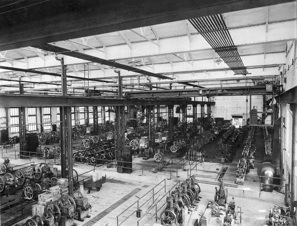 Several rows of stationary engines lined up on the first floor of International Harvester's Milwaukee Works. The factory was owned by the Milwaukee Harvester Company until 1902. The original caption read: "a modern engine manufactory - first floor at Milwaukee."