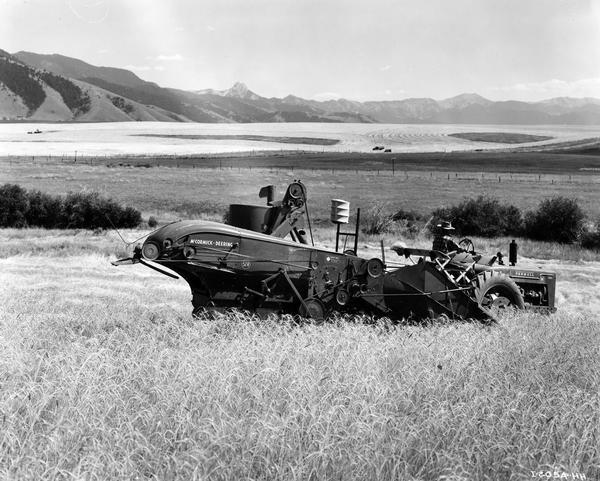 Farmer Paul Eblen operating a McCormick-Deering Farmall M tractor with attached McCormick-Deering no. 52-R combine in a 110 acre wheat field. The machines were owned by L.S. Eblen (father) and Paul Eblen (son), who had 1200 acres at the base of the mountains in Gallatin National Forest.
