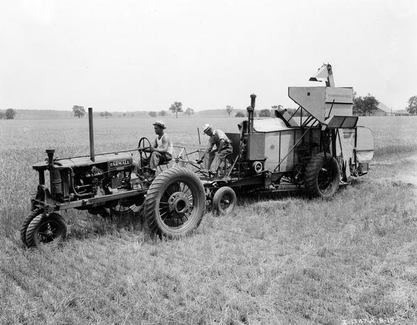 Farmers combining wheat on Purdue University's Edgewood Farm using an air-tired McCormick-Deering combine (harvester-thresher) and Farmall F-20 tractor.