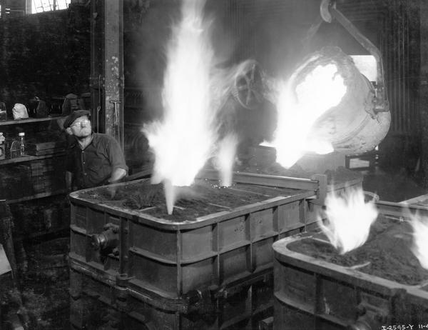 Worker pours molten metal into a mold for a TracTracTor (crawler tractor) main frame at International Harvester's Milwaukee Works foundry.