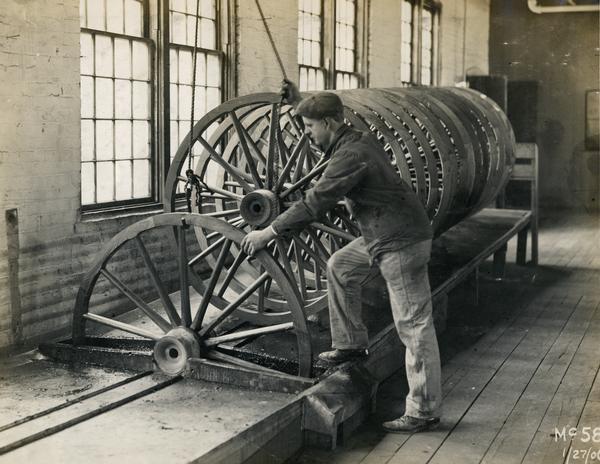 Worker turning a wooden wagon wheel in a groove at International Harvester's Weber Works in Auburn Park.  The factory was owned by the Weber Wagon Company until 1904, when it was purchased by International Harvester.