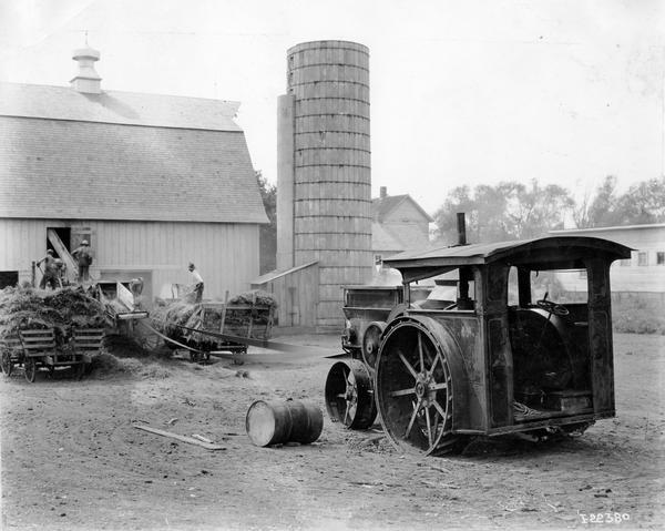 International Titan 18-35 H.P. tractor running a belt-driven ensilage cutter and blower fed by three farmers. The 18-35 gas or kerosene gear drive Titan was produced ca. 1913-1916.