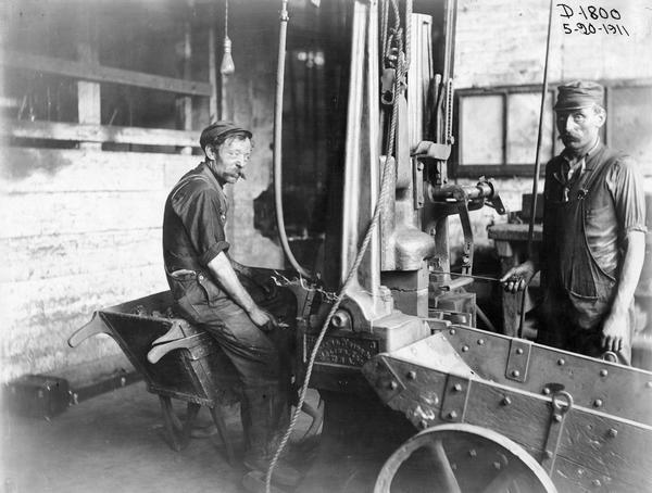 Two workers in the "drop hammer malleable foundry" at International Harvester's Deering Works. The factory was owned by the Deering Harvester Company before 1902. It was located at Fullerton and Clybourn Avenues.