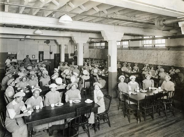 Slightly elevated view of female workers gathered in the women's lunch room at the International Harvester's Osborne Works twine mill. The factory was owned by the D.M. Osborne Company until 1903, when it became part of International Harvester.