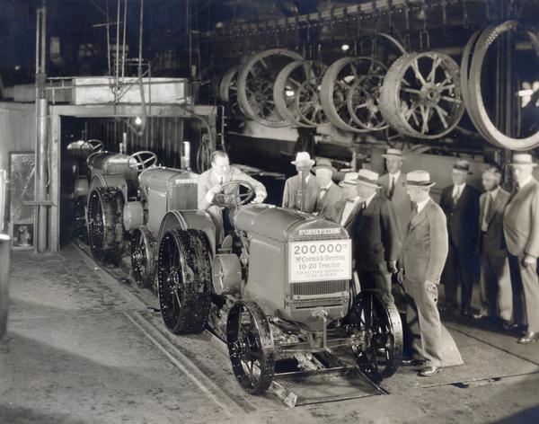 Cyrus McCormick III drives the 200,000th McCormick-Deering 10-20 tractor off of the assembly line at International Harvester's Tractor Works. Gathered for the occasion are company executives (left to right) P.F. Shryer, general superintendent, tractor production; C.H. Haney, director of foreign sales; C.R. Morrison,, assistant domestic sales manager; P.Y. Timmons, in charge of tractor and thresher sales; J.H. Waring, superintendent of Tractor Works; (rear row) J.F. Jones, director of domestic and Canadian sales; M.F. Holahan, domestic sales manager; and E.F. Bolte, Canadian sales manager.