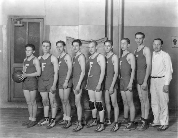 International Harvester mens' basketball team from an unknown company factory or office. The men have a letter "F" on their uniforms.