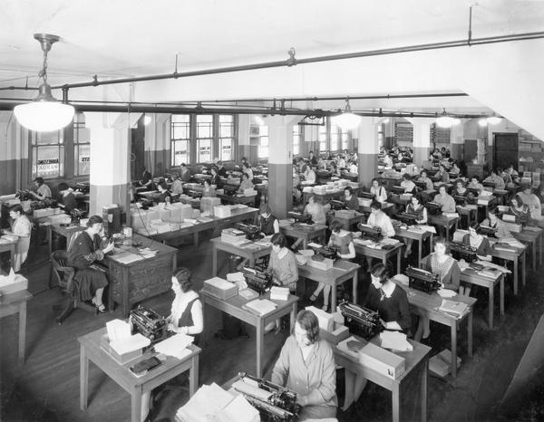 Several female office workers in an office of International Harvester's "Harvester Press."